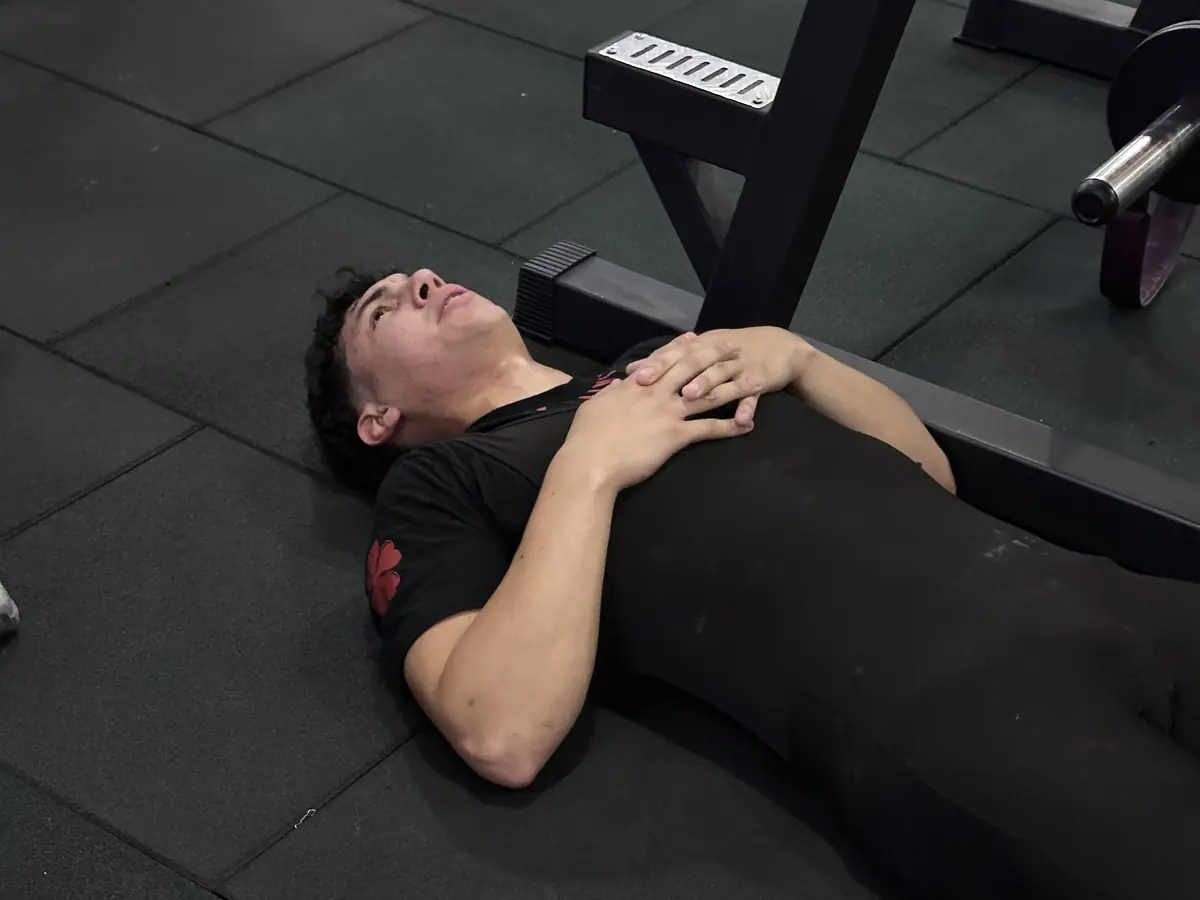 Ali Rondón descansando en el piso entre series durante un entrenamiento de fuerza.